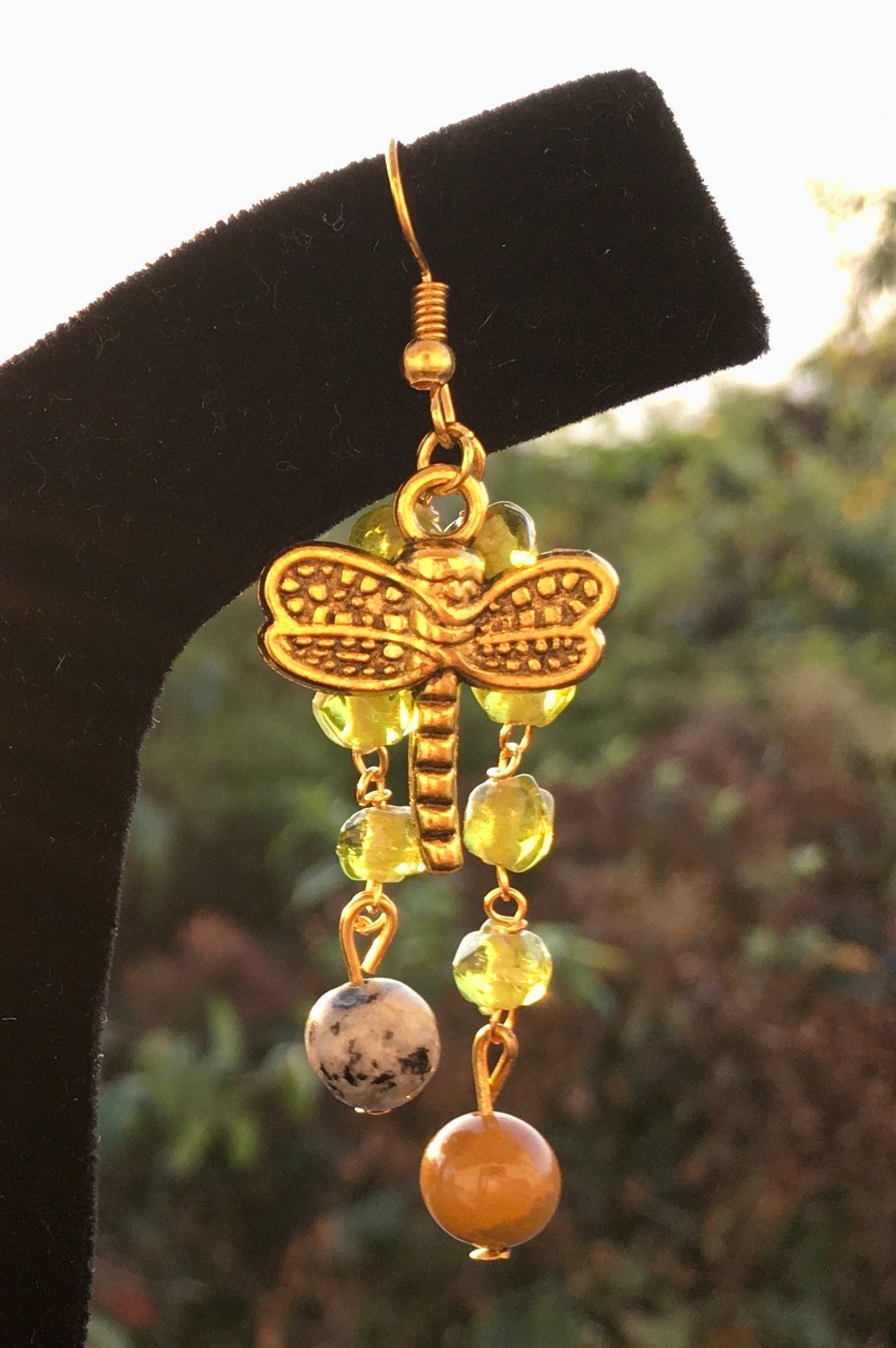 Soar into wisdom and serenity with our dragonfly dangle earrings, featuring sodalite and peach aventurine. These enchanting earrings symbolize transformation, intuitEarringsSpectakWinged Wisdom