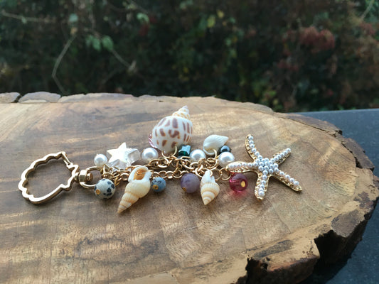 Embrace the essence of goa, with this beautiful  keychain. Made with genuine shells and crystals, this charming accessory adds a touch of bohemian charm to your keysKeychainSpectakBohemian Rhapsody